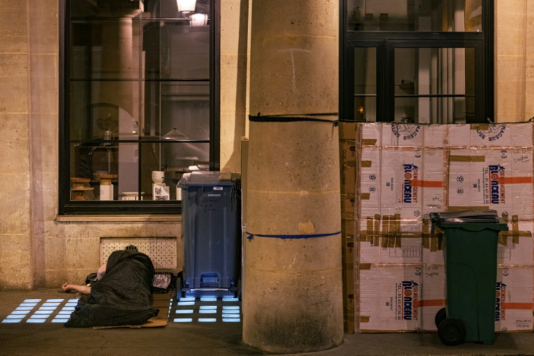 Un sans-abri dort sur un trottoir à Paris, le 4 juin 2025 ( AFP / Joel Saget )