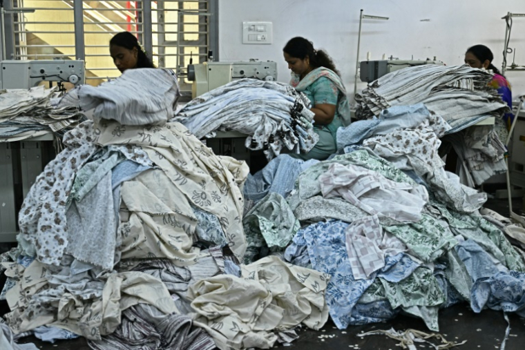 Des ouvrières confectionnent des vêtements sur des machines à coudre dans une usine de fabrication à Bengaluru, en Inde, le 25 août 2025 ( AFP / Idrees MOHAMMED )