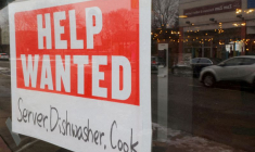 Une pancarte "Help Wanted" est accrochée à la fenêtre d'un restaurant à Medford