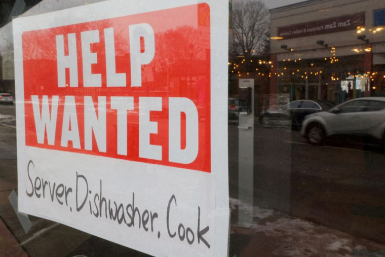 Une pancarte "Help Wanted" est accrochée à la fenêtre d'un restaurant à Medford