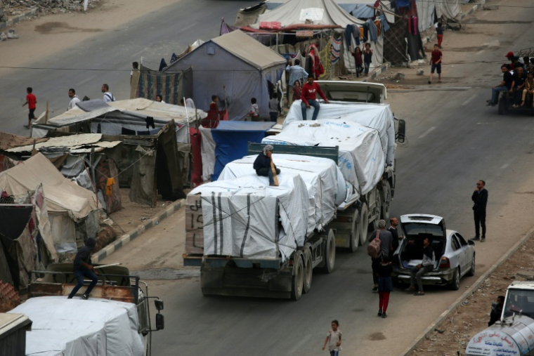 Des camions d'aide humanitaire arrivent à Nousseirat, dans le centre de la bande de Gaza, le 12 octobre 2025 ( AFP / Eyad BABA )