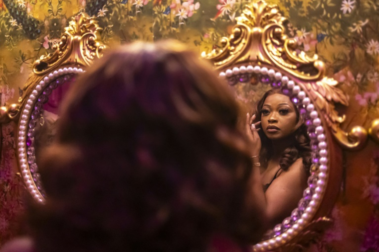 Une cliente se regarde dans le miroir dans les toilettes du restaurant et salon Zaza à Lagos, le 23 août 2025 au Nigeria ( AFP / OLYMPIA DE MAISMONT )