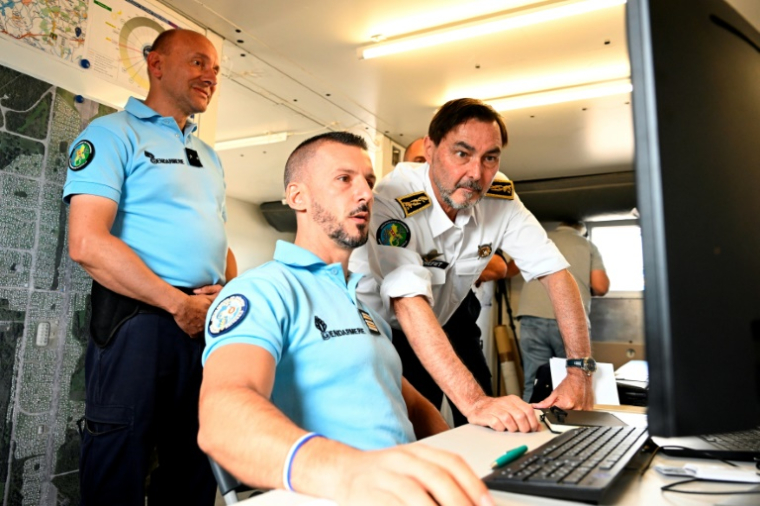 Le préfet de la Moselle Pascal Bolot (à droite) et le commandant du groupement de gendarmerie, le général Marc Peyrar (à gauche), surveillent les arrivées de caravanes sur l'ancienne base aérienne de Grostenquin, en Moselle, le 22 août 2025 ( AFP / Jean-Christophe VERHAEGEN )