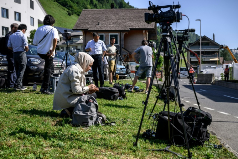 Des journalistes attendent devant le complexe hôtelier de luxe de Bürgenstock, en Suisse, avant le début de négociations de paix entre l'Iran et les Etats-Unis, le 19 juin 2026 ( AFP / Fabrice COFFRINI )