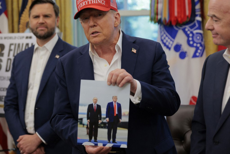 Donald Trump tenant une photo delui-même et de Vladimir Poutine, à Washington, aux États-Unis, le 22 août 2025. ( GETTY IMAGES NORTH AMERICA / CHIP SOMODEVILLA )