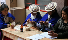 Des femmes misak autochtones font du crochet en attendant les électeurs dans un bureau de vote lors de l'élection présidentielle à la réserve indigène de Guambia, dans le département du Cauca, en Colombie, le 31 mai 2026 ( AFP / Joaquin SARMIENTO )