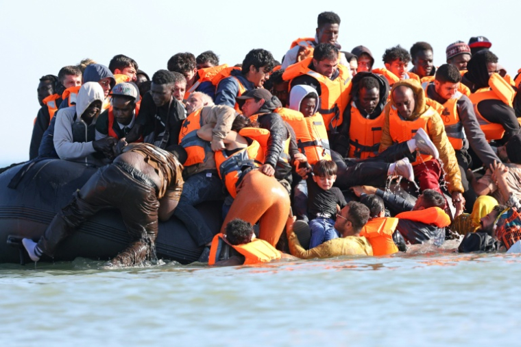 Des migrants montent à bord d'une embarcation de passeurs pour tenter de traverser la Manche au large de la plage de Gravelines, dans le nord de la France, le 29 juillet 2026 ( AFP / Francois LO PRESTI )