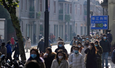 Des personnes portant des masques de protection marchent dans une rue à Shanghai, en Chine