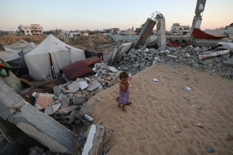 Un enfant palestinien marche à côté des débris d'un bâtiment détruit dans le camp de Bureij dans le centre de la bande de Gaza, le 3 septembre 2025 ( AFP / Eyad BABA )
