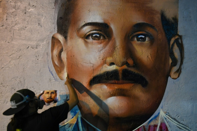 Le graffeur Wolfgang Salazar, alias Badsura, met la touche finale à un portrait du médecin vénézuélien Jose Gregorio Hernandez sur un mur de Caracas, le 27 avril 2021 ( AFP / Federico PARRA )
