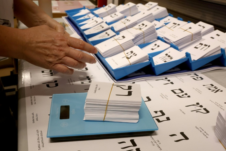 Un employé pèse des bulletins de vote dans une imprimerie, avant les élections législatives à Kiryat Gat, dans le sud d'Israël, le 8 octobre 2026 ( AFP / JACK GUEZ )