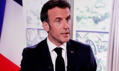 Le président français Macron est vu sur un écran alors qu'il assiste à une interview à Paris