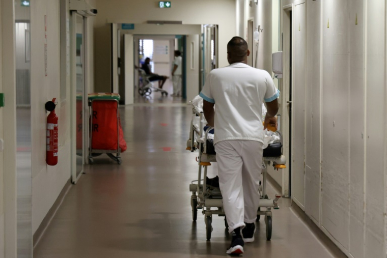 Un soignant transporte un patient atteint du chikungunya dans les couloirs du Centre Hospitalier Ouest Réunion (CHOR) à Saint Paul, sur l'île de La Réunion, le 10 avril 2025 ( AFP / Richard BOUHET )