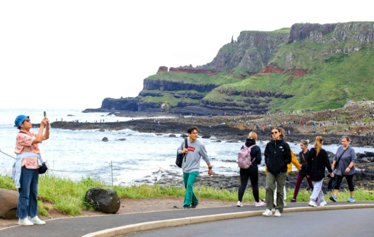 Des touristes visitent la Chaussée des Géants, site naturel près de Bushmills en Irlande du Nord, le 8 juillet 2025 ( AFP / PAUL FAITH )