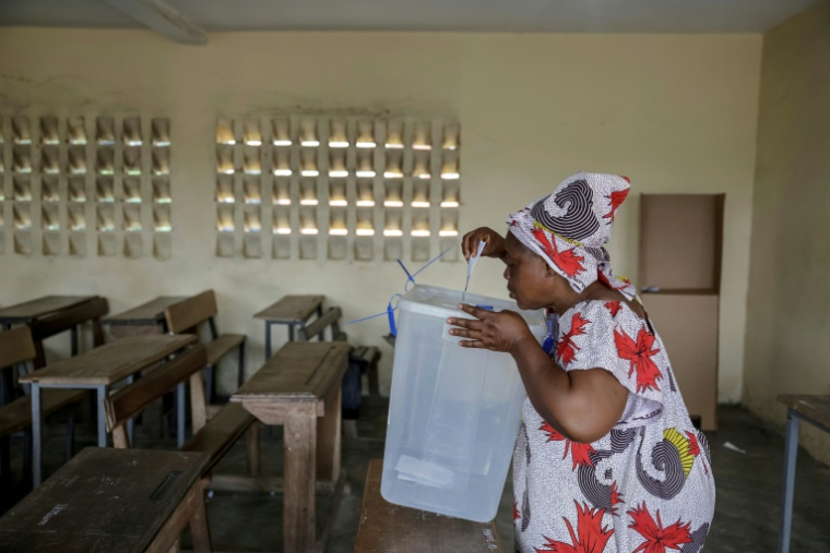 Une femme dépose son bulletin dans l'urne lors de la présidentielle ivoirienne, le 25 octobre 2025 à Abidjan  ( AFP / EMMANUEL CROSET )