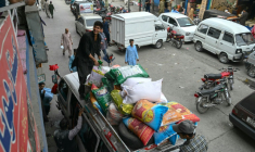 Des habitants chargent des sacs de nourriture sur le toit d'une camionnette au marché de Muzaffarabad, le 2 mai 2025 au Cachemire pakistanais ( AFP / Farooq Naeem )