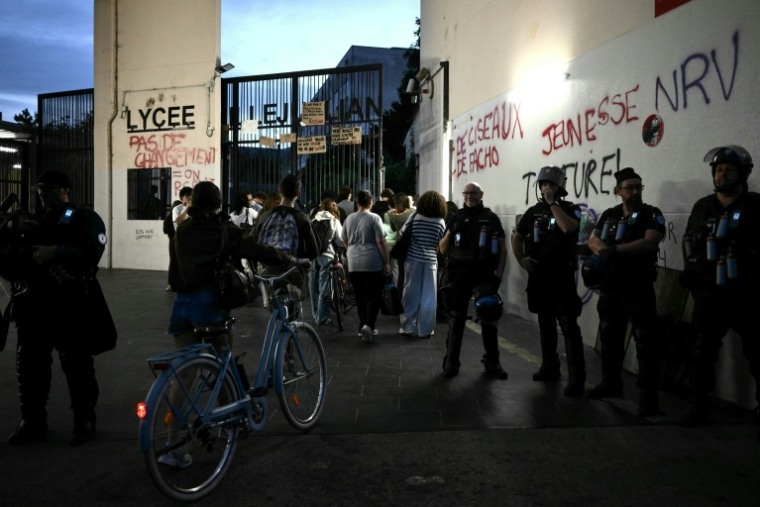 Des policiers près des portes du lycée Camille-Jullian de Bordeaux pour sécuriser l'arrivée des élèves, le 5 octobre 2026 ( AFP / Philippe LOPEZ )