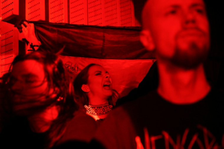 La chanteuse bélarusse Katsiaryna Mankevitch, nom de scène "Nokt", crie en assistant à un concert du groupe de metal ukrainien "1914", à Varsovie, le 25 mars 2026 ( AFP / Sergei GAPON )