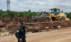 Un bulldozer comble un cratère près d'une route menant à l'aéroport de Tel-Aviv, provoqué par la  chute d'un missile, le 4 mai 2025 ( AFP / Jack GUEZ )