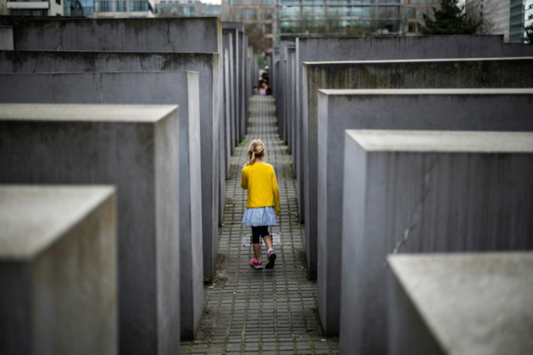 Une enfant joue entre les stèles du Mémorial de l'Holocauste à Berlin, le 14 avril 2025 ( AFP / John MACDOUGALL )