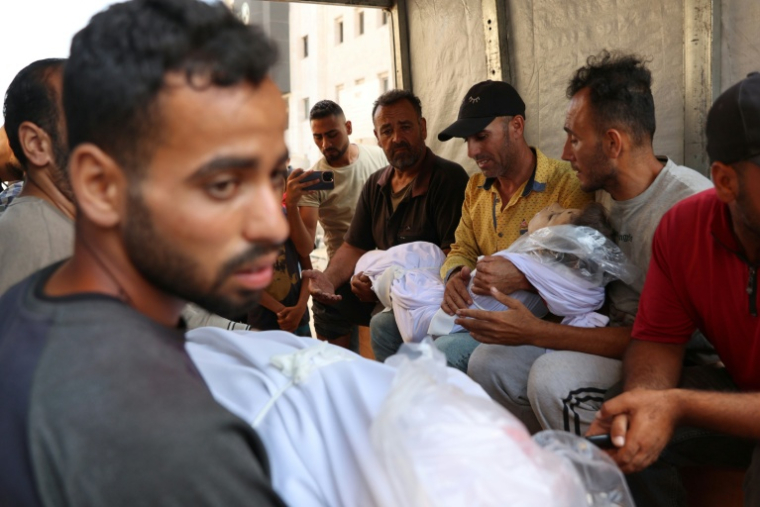 Des Palestiniens portent le corps d'un enfant tué dans une frappe israélienne, à Gaza-ville le 28 juin 2025 ( AFP / Omar AL-QATTAA )