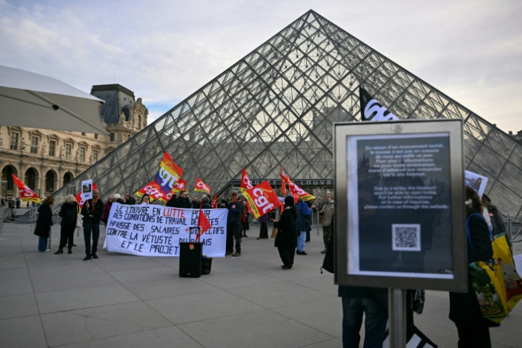 Des membres du syndicat CGT manifestent devant l'entrée du Louvre, à Paris, le 15 décembre 2025 ( AFP / Blanca CRUZ )