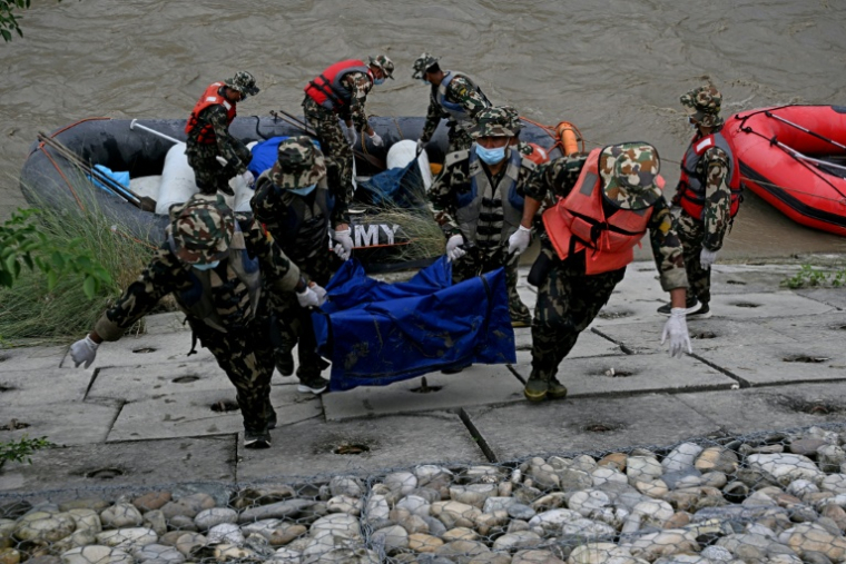 Des soldats transportent les corps de victimes des inondations lors d'une opération de recherche le long de la rivière Narayani, à Bharatpur, dans le district de Chitwan, le 31 août 2026 au Népal ( AFP / PRAKASH MATHEMA )