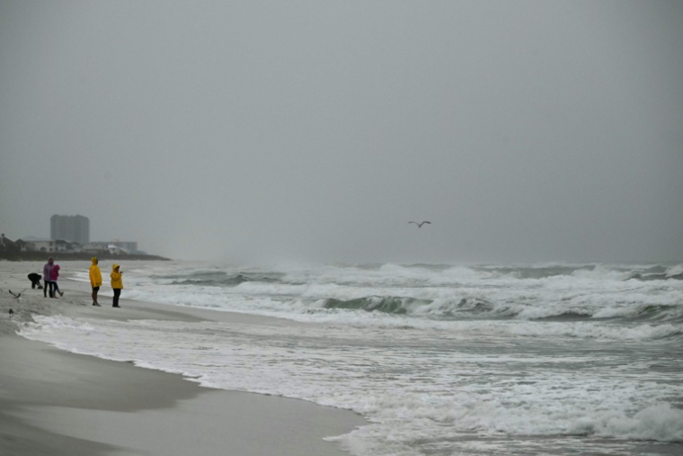 Des personnes observent les fortes vagues à Pensacola Beach à l'approche de l'ouragan Isaias, le 9 octobre 2026 en Floride ( AFP / RONALDO SCHEMIDT )