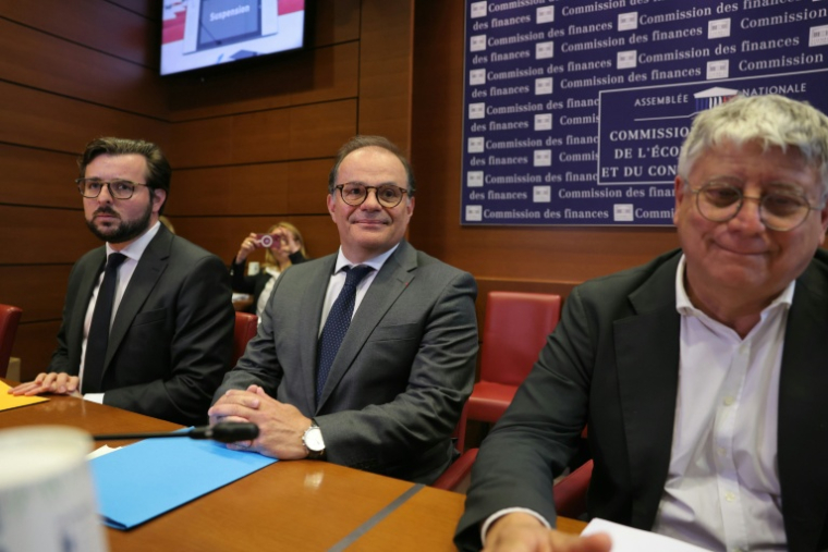 (g-d) Le député Philippe Brun (Socialistes et Apparentés), l'ancien secrétaire général de l'Elyséee et candidat au poste de gouverneur de la Banque de France, Emmanuel Moulin, et le député Eric Coquerel (LFI) assistent à une audition devant la commission des finances de l'Assemblée nationale le 20 mai 2026 à Paris ( AFP / Thomas SAMSON )