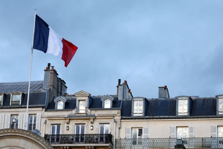 Photo d'un drapeau français qui flotte au-dessus de l'entrée du palais de l'Elysée à Paris