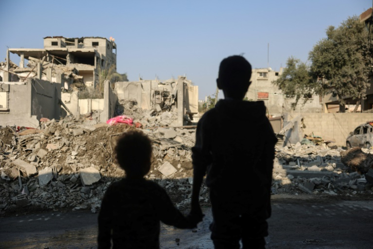 Des enfants regardent les bâtiments détruits après une frappe israélienne dans le camp de réfugiés de Nousseirat, dans le centre de la bande de Gaza, le 7 novembre 2024 ( AFP / Eyad BABA )