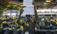 Lors d'une réunion du Congrès national africain (ANC) à Johannesburg, le 16 décembre 2022, un délégué brandit une pancarte où l'on peut lire "Phala Phala", en référence à un vol survenu dans la ferme du même nom appartenant au président sud-africain Cyril Ramaphosa ( AFP / GUILLEM SARTORIO )