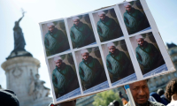 Des portraits d'Aboubakar Cissé, tué à coups de couteau à la mosquée de La Grand-Combe fin avril, lors d'un rassemblement en sa mémoire à Paris, le 1er mai 2025 ( AFP / Ian LANGSDON )
