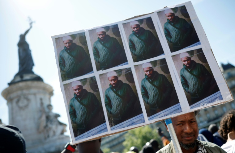 Des portraits d'Aboubakar Cissé, tué à coups de couteau à la mosquée de La Grand-Combe fin avril, lors d'un rassemblement en sa mémoire à Paris, le 1er mai 2025 ( AFP / Ian LANGSDON )