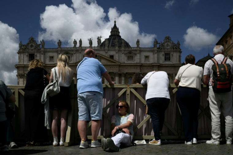Des touristes place Saint-Pierre, au Vatican, durant le conclave, le 8 mai 2025 ( AFP / JEFF PACHOUD )