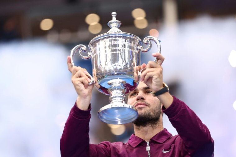 Carlos Alcaraz tenant son trophée après sa victoire à l'US Open, à New York, le 7 septembre 2025 ( AFP / CHARLY TRIBALLEAU )