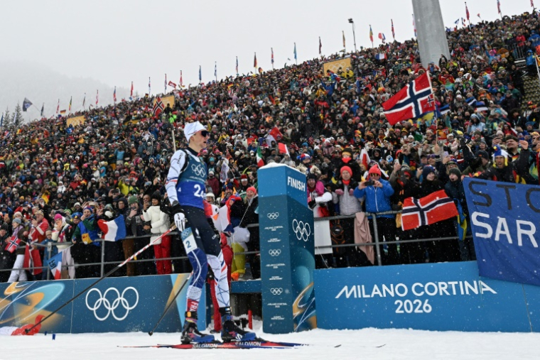 Le biathlète français Eric Perrot passe la ligne d'arrivée en tête du relais 4 x 7,5 km des JO-2026 le 17 février 2026 à Anterselva en Italie ( AFP / Franck FIFE )