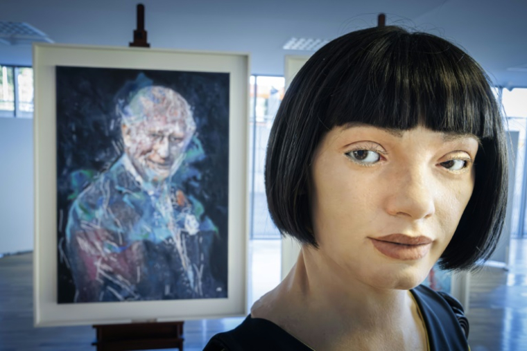 Le robot artiste gynoïde Ai-Da devant le portrait du roi Charles III qu'il a peint, exposé en marge du Sommet mondial AI for Good organisé par l'Union internationale des télécommunications (UIT) à Genève, le 9 juillet 2025 ( AFP / Valentin Flauraud )
