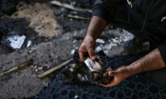 Un homme palestinien tient une page brûlée d'un Coran à l'intérieur de la mosquée Hajja Hamida à Dayr Istiya, dans le nord de la Cisjordanie occupée, le 13 novembre 2025, après une attaque présumée de colons juifs ( AFP / Zain JAAFAR )
