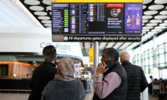 Des voyageurs vérifient le tableau des départs affichant les vols annulés vers les pays du Moyen-Orient dans le contexte du conflit entre les États-Unis, Israël et l'Iran, à l'aéroport d'Heathrow