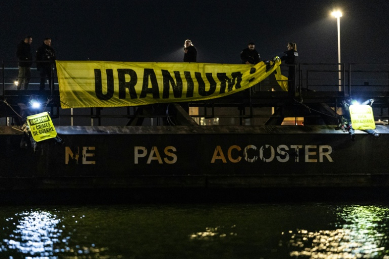 Des policiers retirent une banderole acrochée par des militants de Greenpeace le 2 mars 2026 dans le port de Dunkerque ( AFP / Sameer Al-DOUMY )
