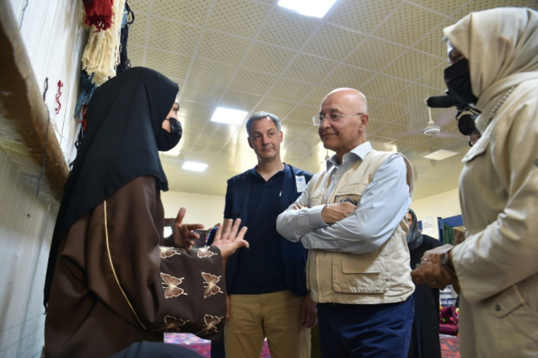 l'administrateur du Programme des Nations unies pour le développement (PNUD), Alexander de Croo (c) et le Haut-Commissaire de l'ONU aux réfugiés, Barham Salih (2e g)  parlent avec une employée d'une fabrique de tapis du district de Nahr-e-Shahi, dans la province de Balkh, le 6 juillet 2026 en Afghanistan ( AFP / Atif ARYAN )
