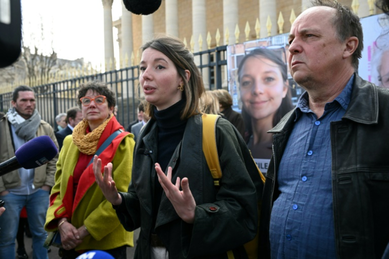 La soeur de Cécile Kohler, Noémie Kohler (C), entourée par ses parents Mireille (G) et Pascal Kohler (D), le 25 mars 2025 devant l'Assemblée nationale à Paris ( AFP / Bertrand GUAY )
