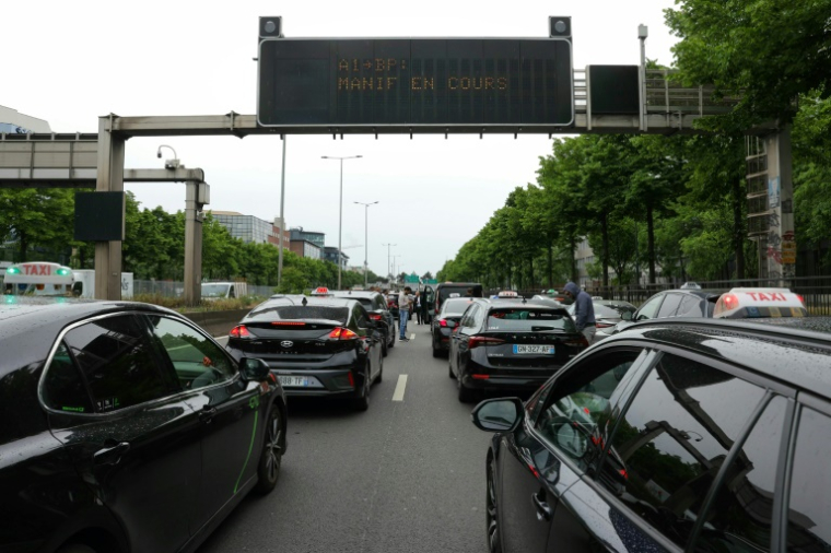 Des chaufeurs de taxis manifestent sur l'autoroute A1 près de Paris, le 21 mai 2025 ( AFP / Thomas SAMSON )