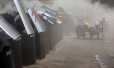 Protesters cover with makeshift shields during an anti-coup protest in Yangon
