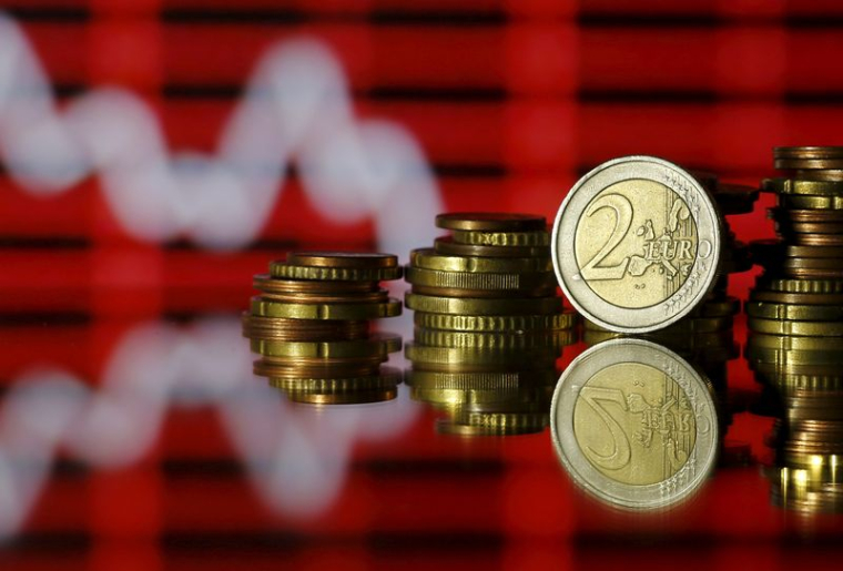 Des pièces en euros devant un graphique boursier