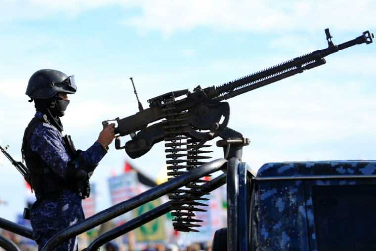 Un agent de sécurité monte la garde lors d'un rassemblement de partisans houthis en solidarité avec l'Iran et le Liban à Sanaa, le 27 mars 2026 au Yémen ( AFP / Mohammed HUWAIS )