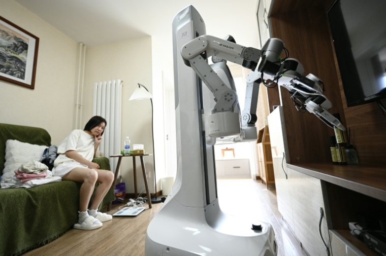 Un robot X Square fait le ménage au domicile d'une cliente, le 21 mai 2026 à Pékin, en Chine ( AFP / WANG Zhao )