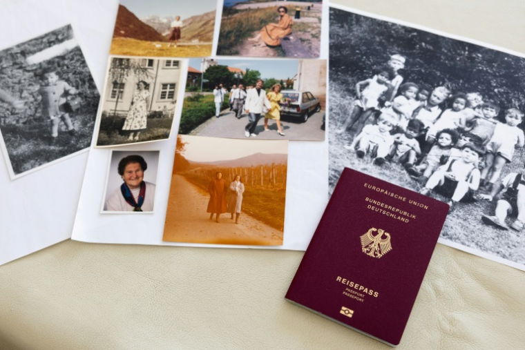 Une photo de Claudine Spire enfant (g), son passeport allemand et des photos de ses proches en Allemagne, lors d'un entretien à son domicile de Chaville, dans la région parisienne, le 9 avril 2025 ( AFP / Xavier GALIANA )