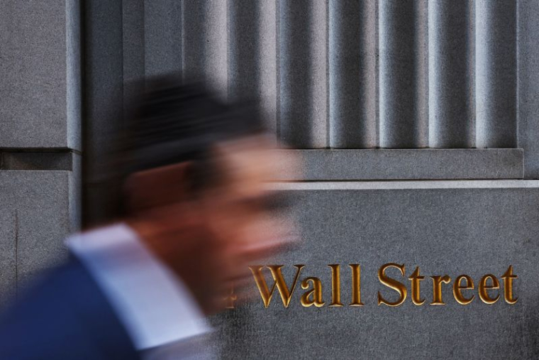 Un homme passe devant un marquage de Wall Street à l'extérieur du bâtiment de la Bourse de New York (NYSE) à New York City